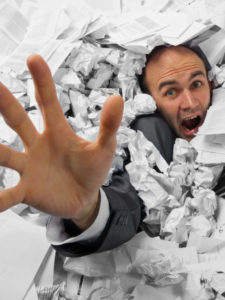 Businessman sinking in heap of documents