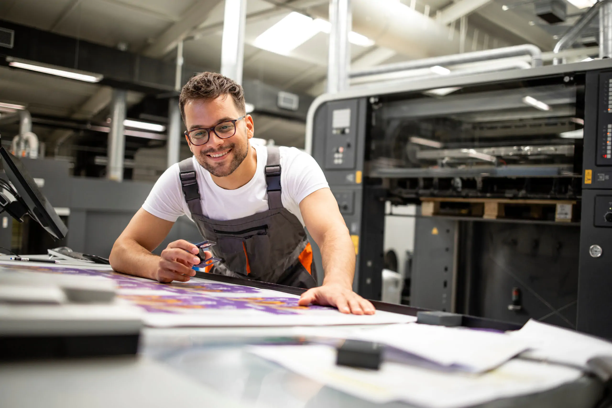 Print house worker controlling printing process quality